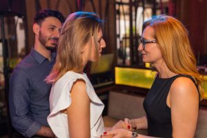 dwie kobiety rozmawiają, mężczyzna stoi