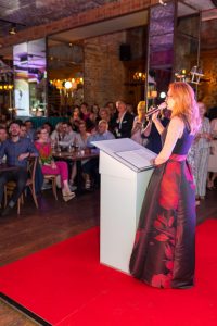 kobieta w długiej spódnicy mówi do mikrofonu