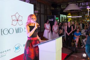 kobieta w okularach, w tle goście